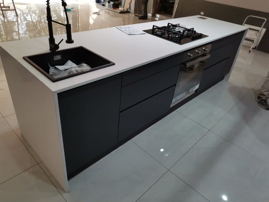 Handleless kitchen island with white stone top, fitted by Nawkham