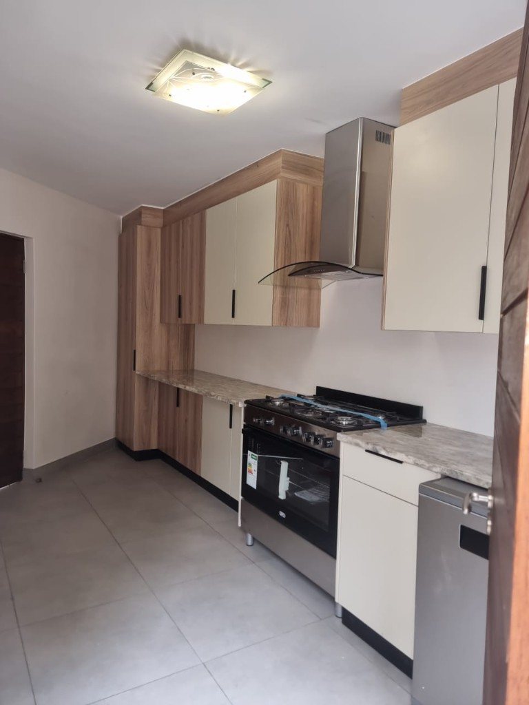 Two-tone cream doors with oak surrounds and a gas range