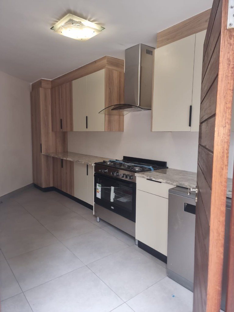 Cream and oak kitchen with gas range, glass hood and tall pantry