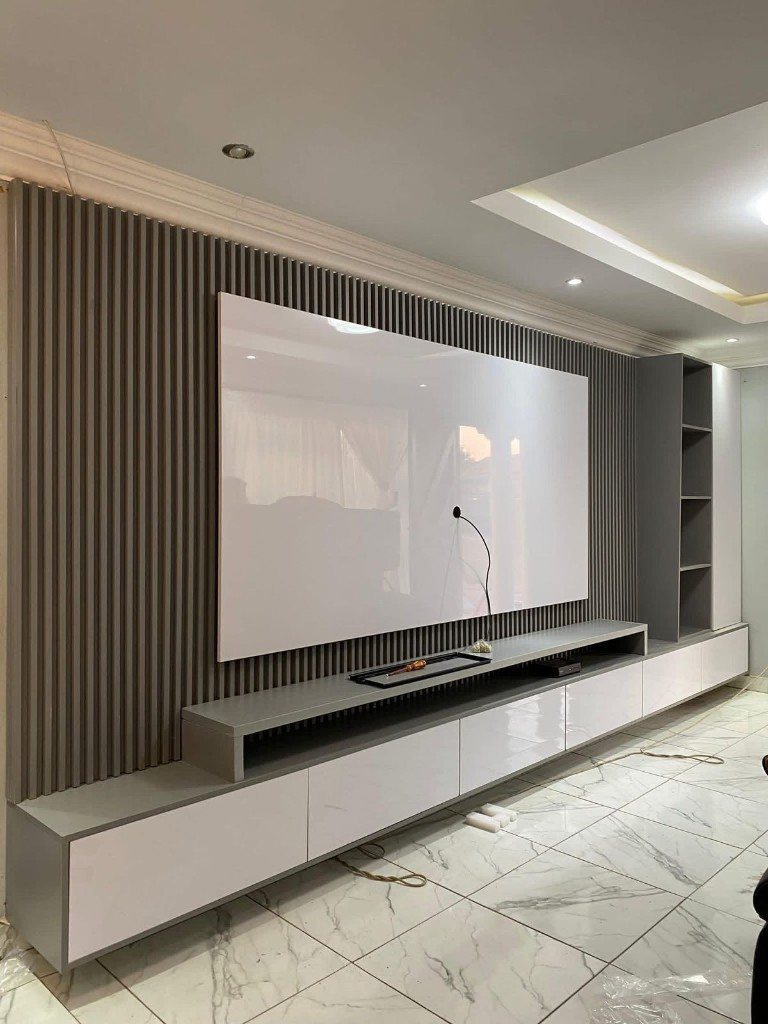 Grey slatted media wall and gloss cabinet