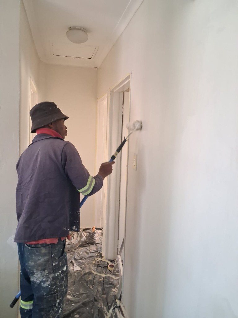 Hallway being painted after skim