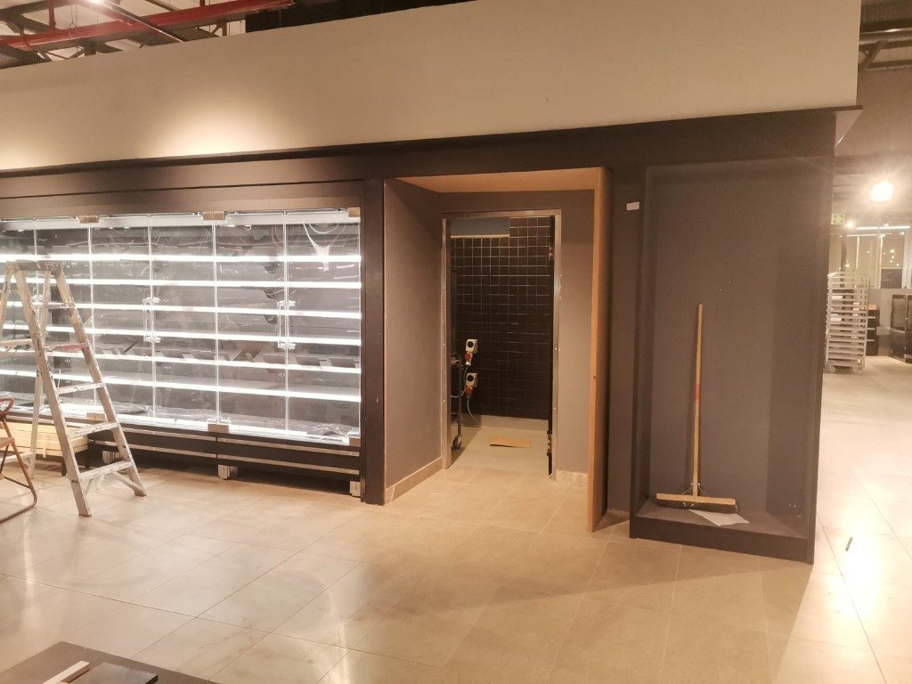 Glass-door fridge built into a charcoal wall