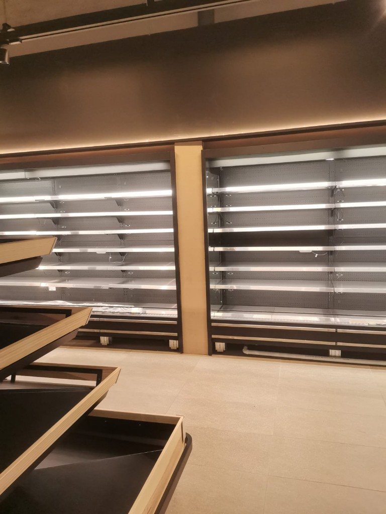 Open fridge decks next to wood produce bins