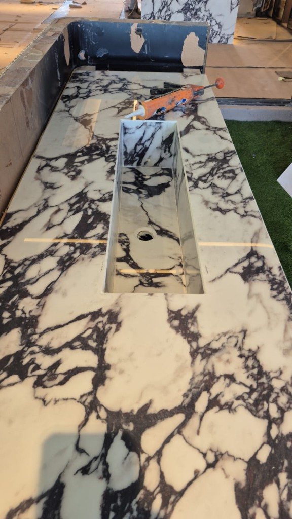 Long marble trough sink being fitted